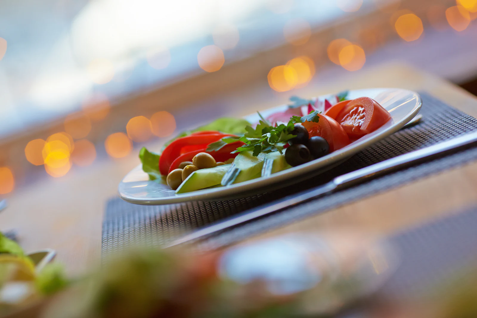 Teller mit Salat, Tomaten und Oliven